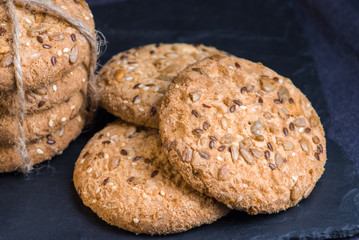 Savory cookies sprinkled with sesame seeds, sunflower on shale board