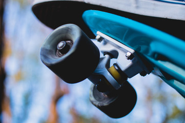 Close-up view of the man standing on the blue plastic penny skateboard. The concept of city...