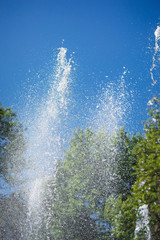 Splashing water fountain against the blue sky