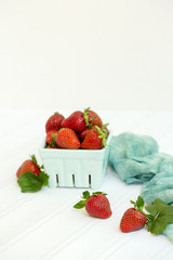 Freshly Picked Strawberries in Green Glass Produce Carton on White Tabletop