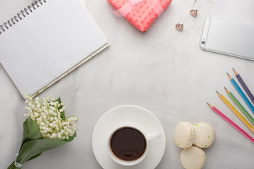 Flatlay with flowers and macaroons, and colored pencils, and a phone and a gift with a blank space for an inscription on a light background. Can be used as a postcard for a holiday