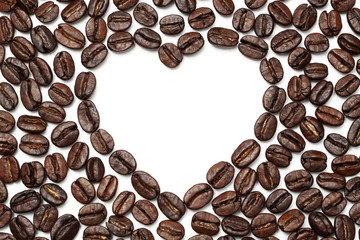 Coffee beans with heart shape on white plate , top view and copy space