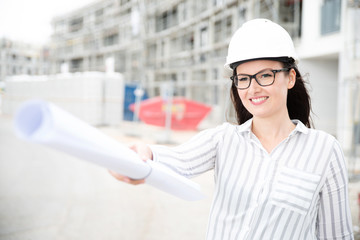 Frau mit Bauhelm auf einer Baustelle 