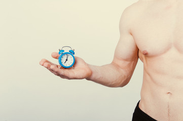 healthcare fitness Time and taking care of yourself concept. Man holding alarm over white background.