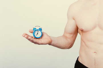 Fototapeta premium healthcare fitness Time and taking care of yourself concept. Man holding alarm over white background.