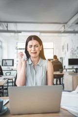 Portrait of disappointed businesswoman crying while looking at notebook computer. Problem at labor...