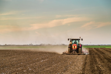 Tractor cultivating field at spring