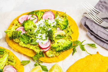 Vegan tacos (pizza, pita) with radish, broccoli and guacamole, top view. Healthy vegan food concept.