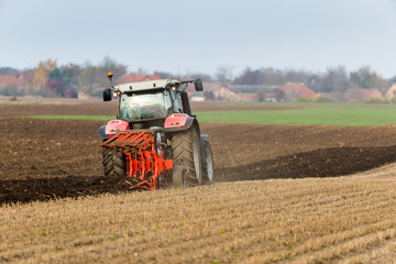 Fototapeta premium Farmer plowing stubble field