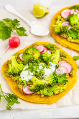 Vegan tacos (pizza, pita) with radish, broccoli and guacamole, top view. Healthy vegan food concept.