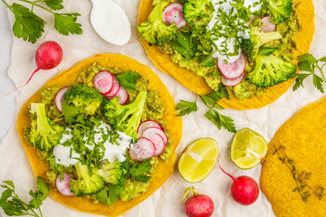 Vegan tacos (pizza, pita) with radish, broccoli and guacamole, top view. Healthy vegan food concept.