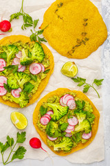 Vegan tacos (pizza, pita) with radish, broccoli and guacamole, top view. Healthy vegan food concept.