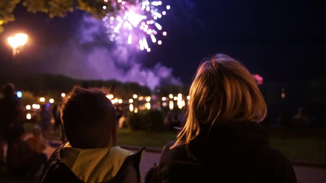 happy family sitting on floor and watching the fireworks