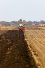 Obraz premium Farmer plowing stubble field