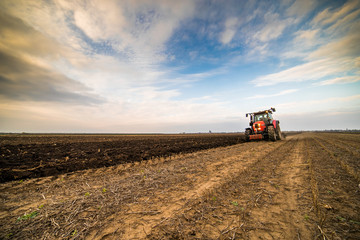 Obraz premium Farmer plowing stubble field