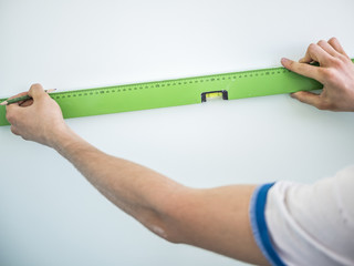 close up hand measuring wall meter distance with pencil in the hand