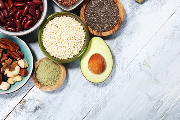 superfood concept on white table with avocado, goji and nuts and seeds.