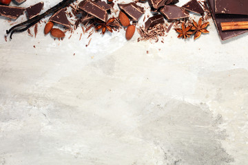 dark chocolate bars  with anise and nutson stone table and broken pieces of cocoa