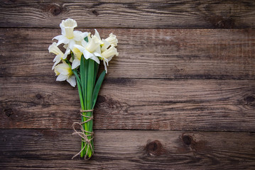 Bouquet of white with yellow daffodils on wooden background