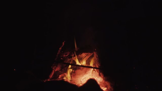 Bonfire in a camp-fire of stones outdoors at dusk