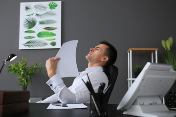 Obraz premium Young man feeling hot in office