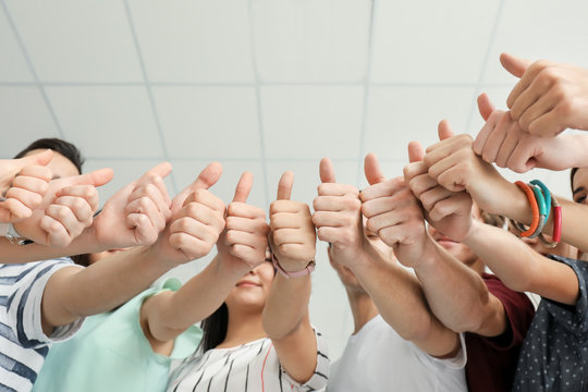 Many people showing thumbs up together as symbol of unity