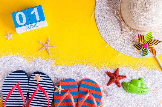 June 1st. Image of june 1 calendar on yellow sandy background with summer beach, traveler outfit and accessories. First summer day. Happy Childrens Day