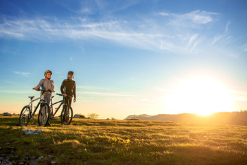 Fototapeta na wymiar Happy mountainbike couple outdoors have fun together on a summer afternoon sunset