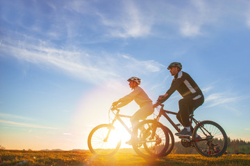 Happy mountainbike couple outdoors have fun together on a summer afternoon sunset © FS-Stock