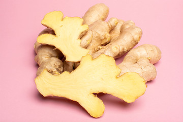 Trendy food flat lay concept on light pink background with fresh big ginger root close up copy space isolated