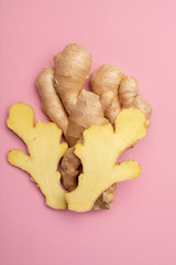Trendy food flat lay concept on light pink background with fresh big ginger root close up copy space isolated