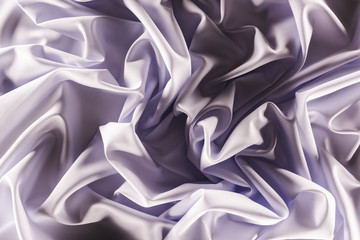 full frame of folded elegant purple silk fabric as background