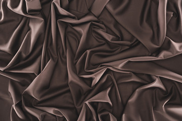 full frame of folded dark silk cloth as background