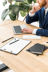 cropped shot of businessman working on laptop at workplace in office