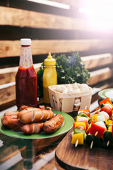 Hot sausages and vegetables with ketchup and mustard grilled for outdoors barbecue