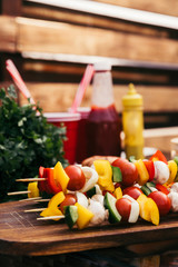 Vegetables on wooden skewers cooked outdoors on table
