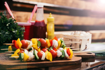 Vegetables on skewers with ketchup and mustard cooked outdoors