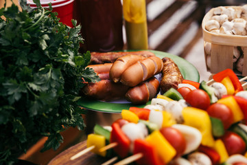 Close-up view of sausages and vegetables grilled for outdoors barbecue