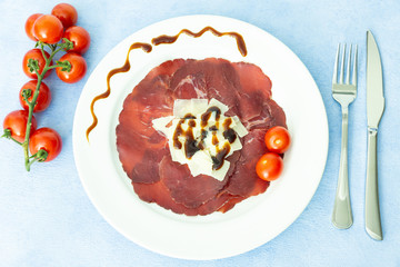 Italian bresaola with parmesan cheese and some drops of balsamic vinegar. It is a typical, tasty and tasty appetizer. Bresaola is a salami among the most dietary