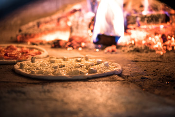 close up view of italian pizza baking in brick oven in restaurant