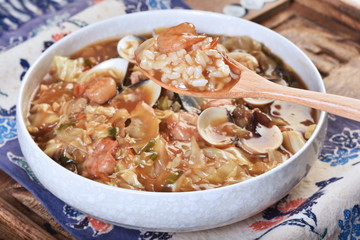 Braise rice with the mixed seafood in a wooden spoon  