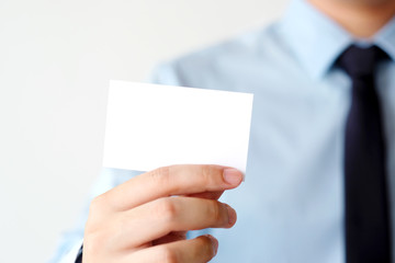 Businessman hand holding blank white business card with copy space for text, business mock up background concept