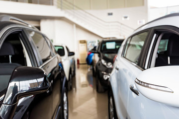 New cars at dealer showroom blurred background