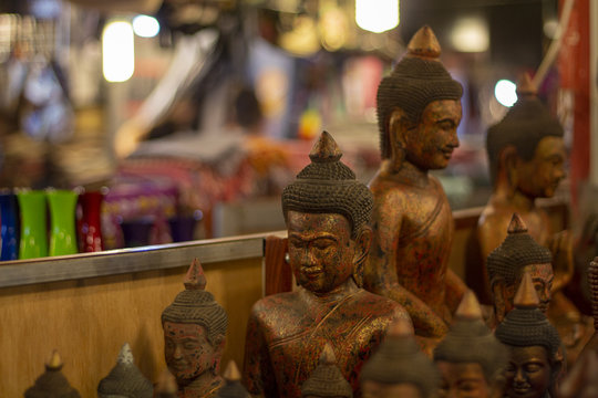 Wooden Buddha figures on souvenir market in Siem Reap, Cambodia. Traditional arts and crafts of Asia.