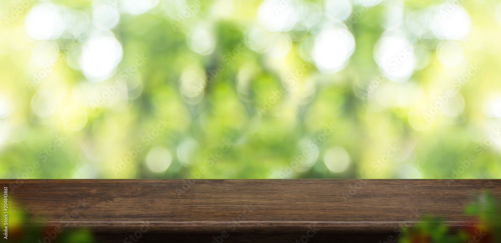 Aufkleber Empty grunge wood table top with blur tree in park with bokeh light at background,Mock up template for display of your design,Banner for advertise of product,panorama view
