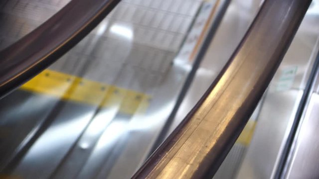 escalator moving down, close-up handrail