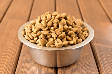 A bowl of dog food on a wooden table