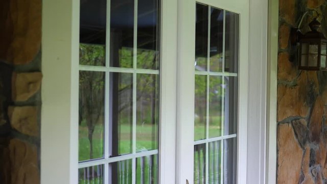 Panning down French doors on beautiful porch entrance to home