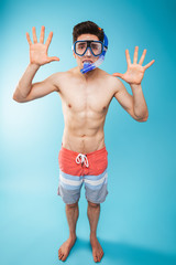 Full length portrait of a cheerful young shirtless man