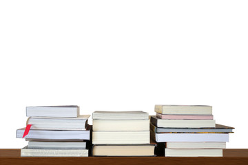 Piles or stack of books for reading and study on wooden shelf on white blank wall background